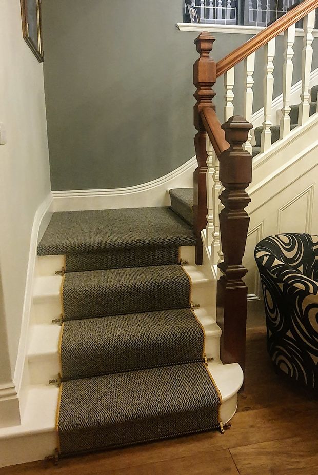 traditional staircase with carpet runner and stair rods

